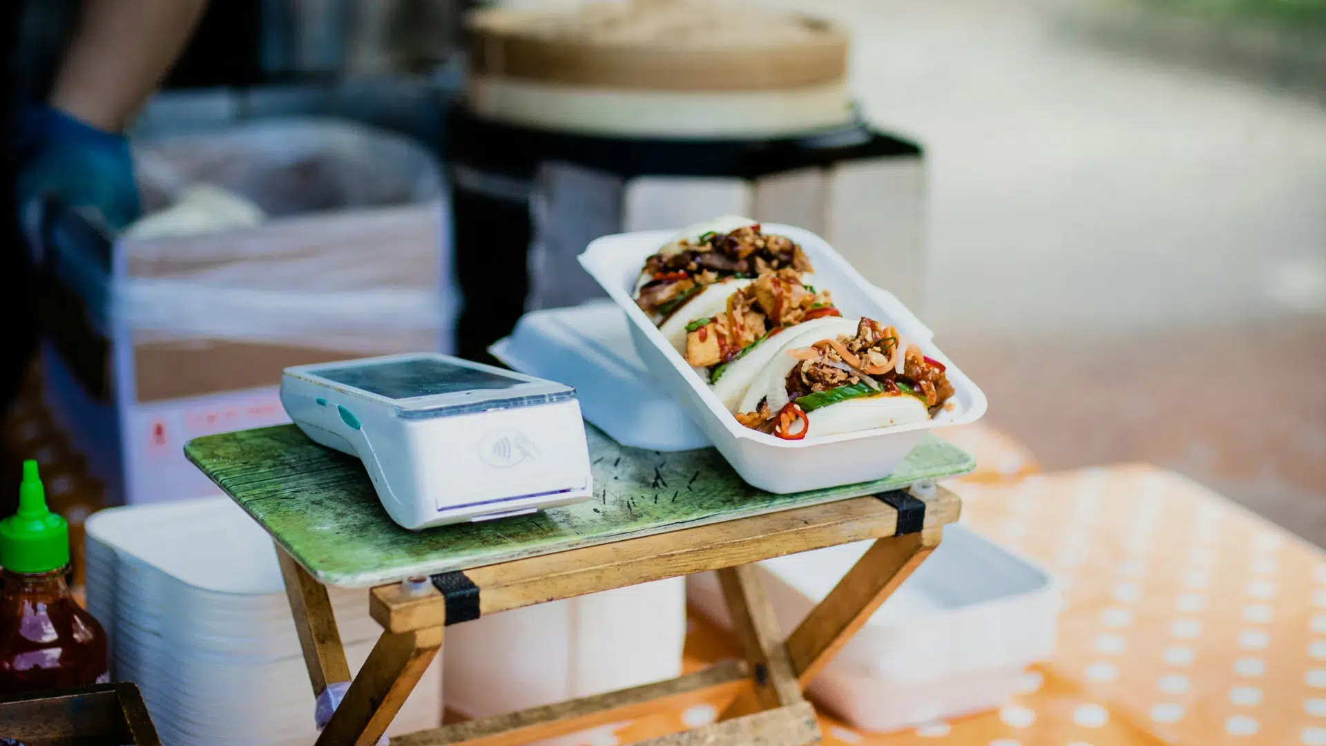 An image of a handheld POS device sitting next to a tray of food.